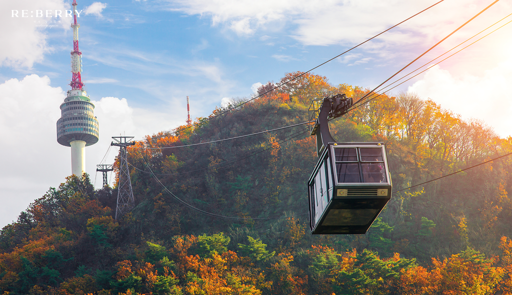 n seoul tower perched atop a hill and a cable car