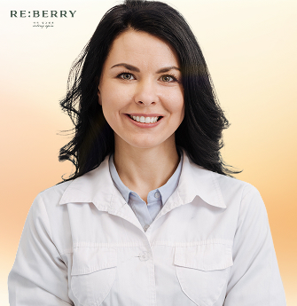 A smiling female dermatologist in a white coat at Reberry Clinic