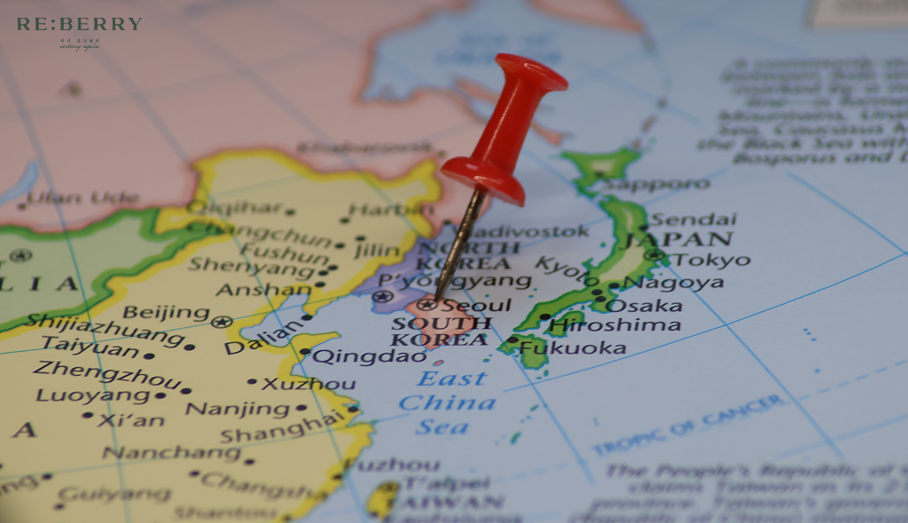 a thumb-pin pointed in south korea in the world map